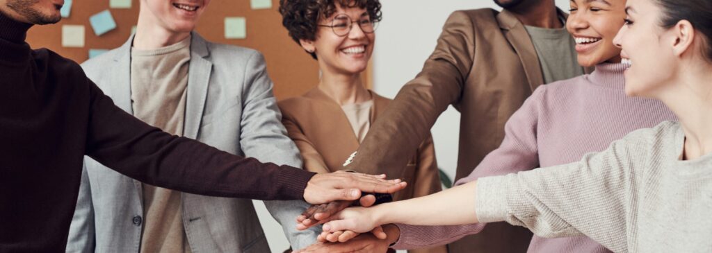 A group of employees putting their hands together to show support.