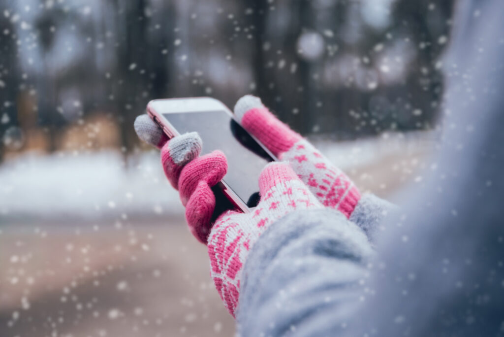 Woman using smartphone in winter