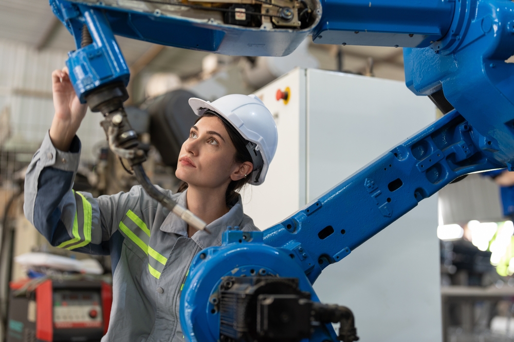 Female automation engineer working on a robotic arm